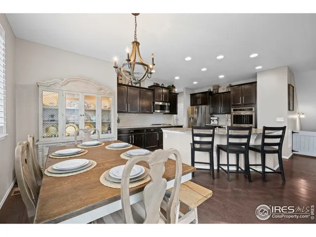 a view of a dining room and livingroom with furniture wooden floor a chandelier