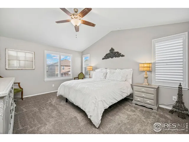 a bedroom with a bed chandelier and a window
