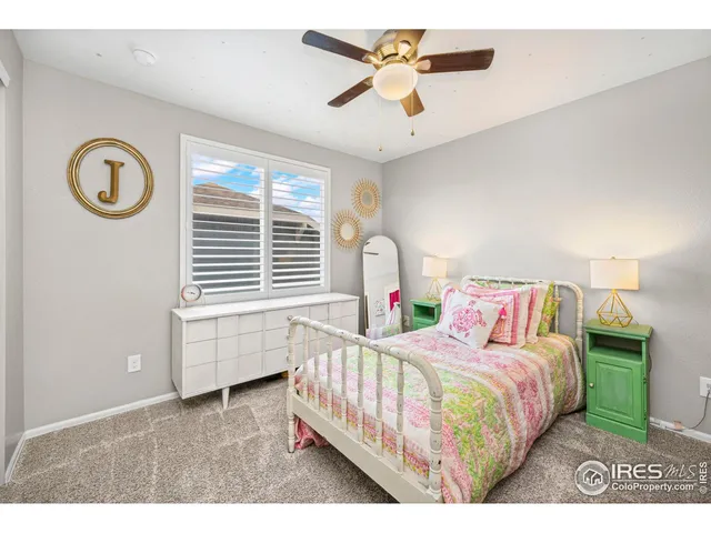 a bedroom with a bed next to a window and a chandelier
