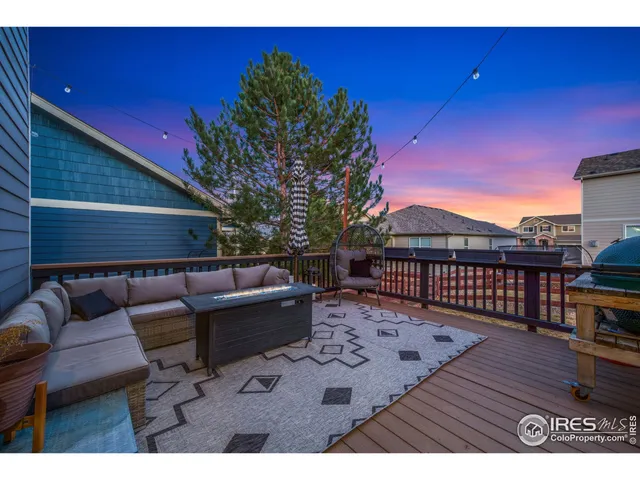a view of a deck with couches table and chairs with wooden floor