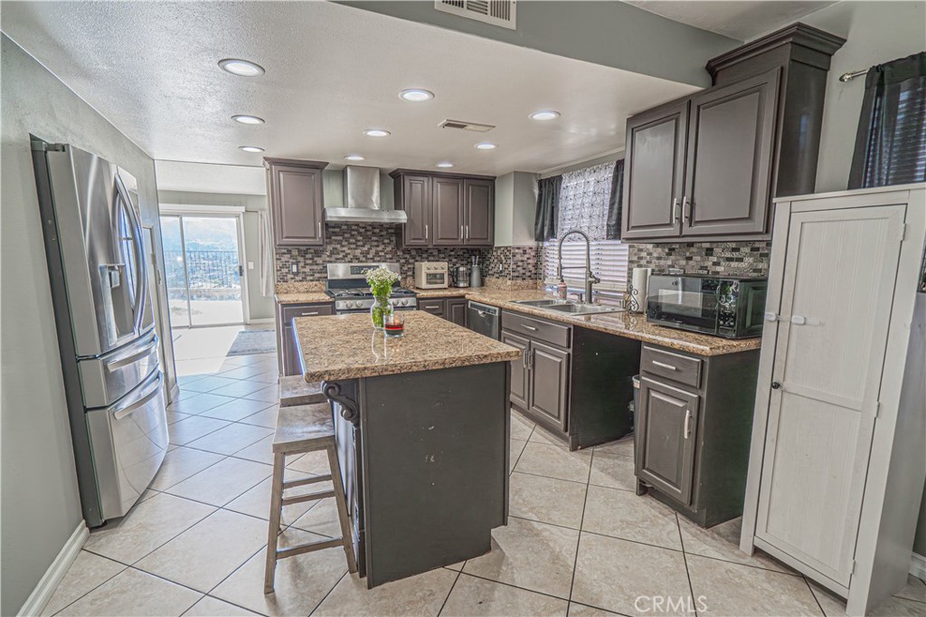 28076 Wildwind Road Canyon Country, CA 91351 - Photo 12 of 48 a kitchen with stainless steel appliances granite countertop a refrigerator stove a sink and dishwasher