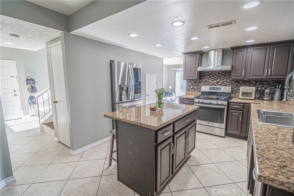 28076 Wildwind Road Canyon Country, CA 91351 - Photo 16 of 48 a kitchen with stainless steel appliances granite countertop a stove top oven a sink a counter top space and cabinets