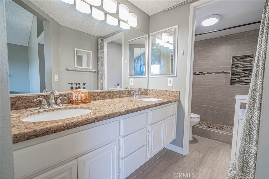 28076 Wildwind Road Canyon Country, CA 91351 - Photo 24 of 48 a bathroom with a granite countertop sink toilet and shower