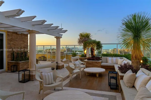 a view of a patio with couches table and chairs potted plants and palm tree