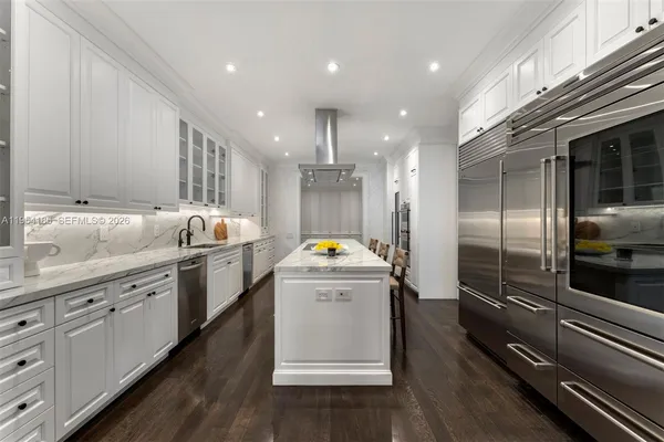a kitchen that has a lot of cabinets in it and wooden floors