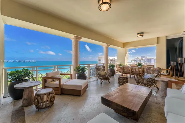 a living room with furniture a rug potted plant and a large window
