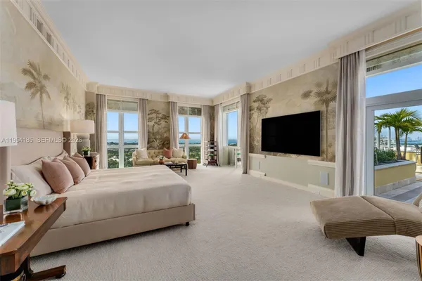 a spacious bedroom with a bed and a flat screen television