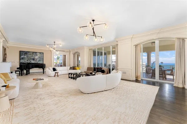 a living room with furniture a chandelier and a flat screen tv