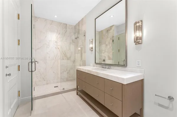a bathroom with a shower sink and mirror