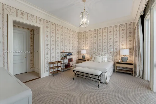 a spacious bedroom with a bed and a chandelier