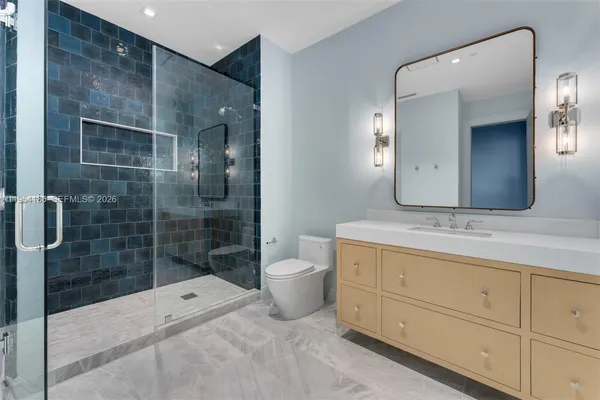 a view of a patio with couches table and chairs under an umbrella with a fire pit
