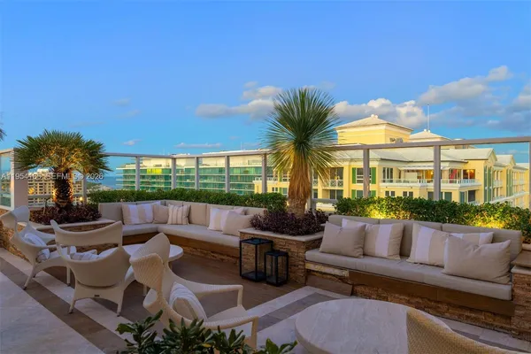 a view of a patio with couches chairs potted plants and palm tree