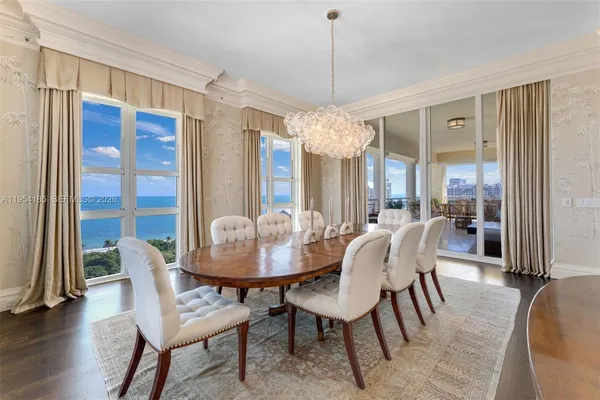 a dining room with furniture a chandelier and wooden floor
