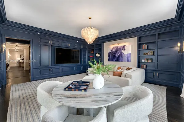 a living room with furniture a chandelier and a flat screen tv