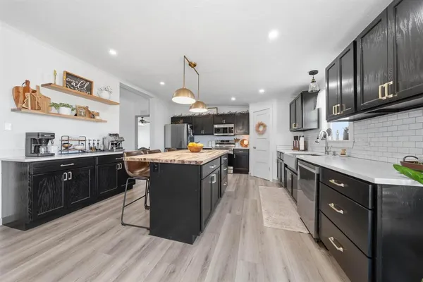 a kitchen with stainless steel appliances granite countertop wooden cabinets a sink dishwasher a stove and a refrigerator