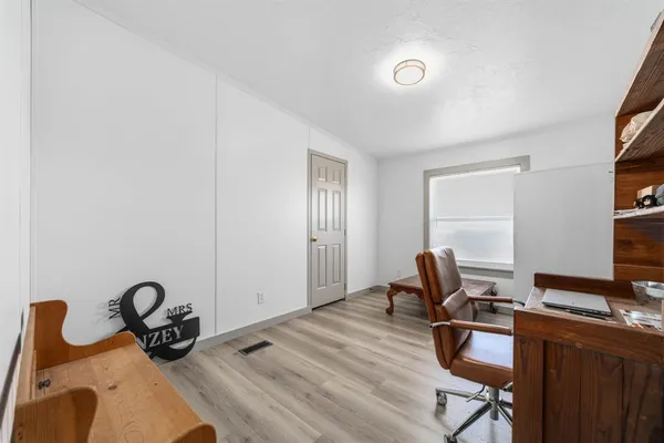 a view of a workspace with furniture and a window