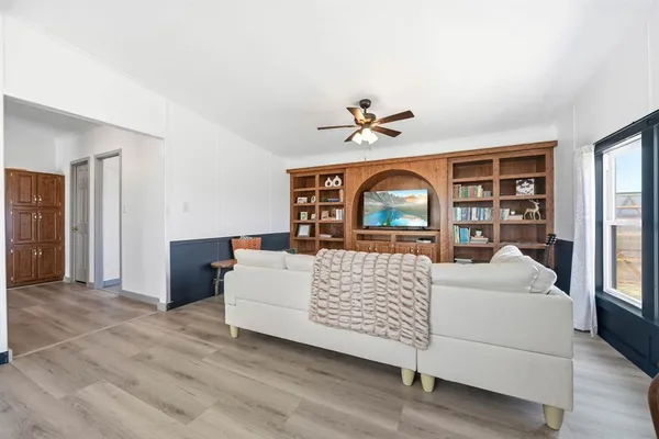 a dining room with furniture a window and wooden floor