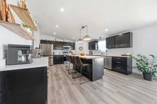 a kitchen with stainless steel appliances kitchen island granite countertop a sink counter space and cabinets