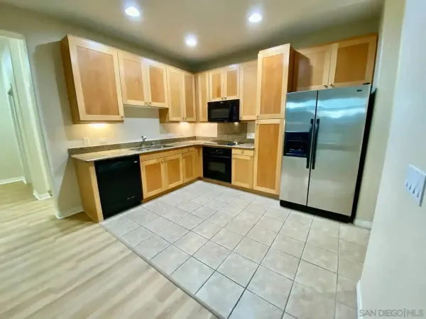 a kitchen with stainless steel appliances granite countertop a refrigerator sink and microwave