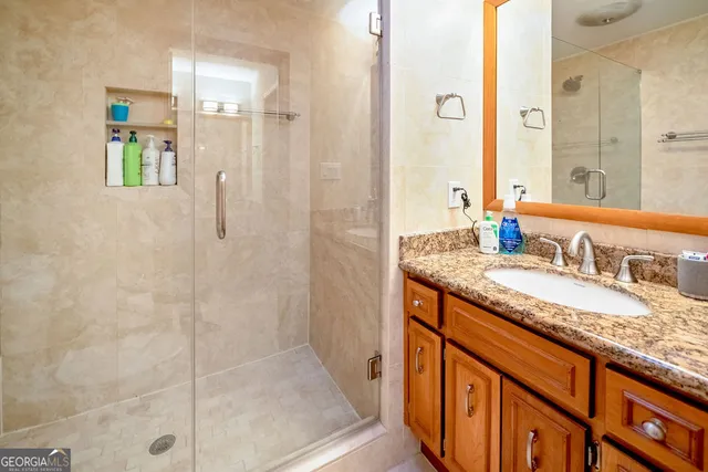a bathroom with a granite countertop sink and a mirror