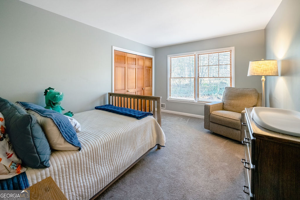 115 Devilla Trace Fayetteville, GA 30214 - Photo 19 of 30 a bedroom with a bed and a couch with window