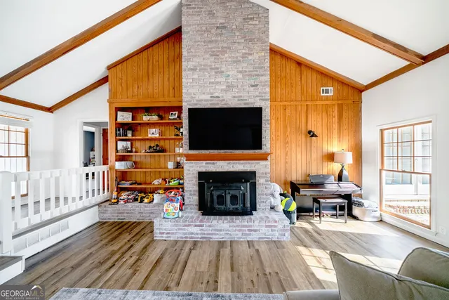 a living room with furniture a fireplace and a flat screen tv
