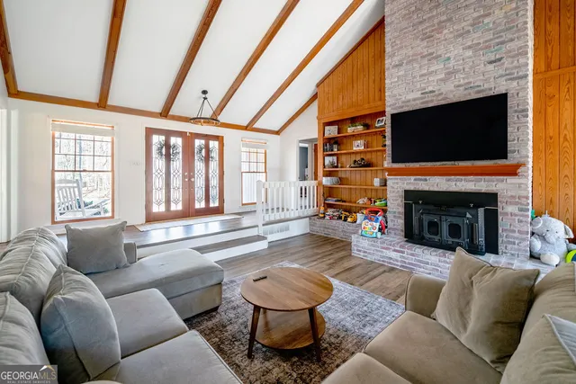 a living room with furniture large window and a fireplace