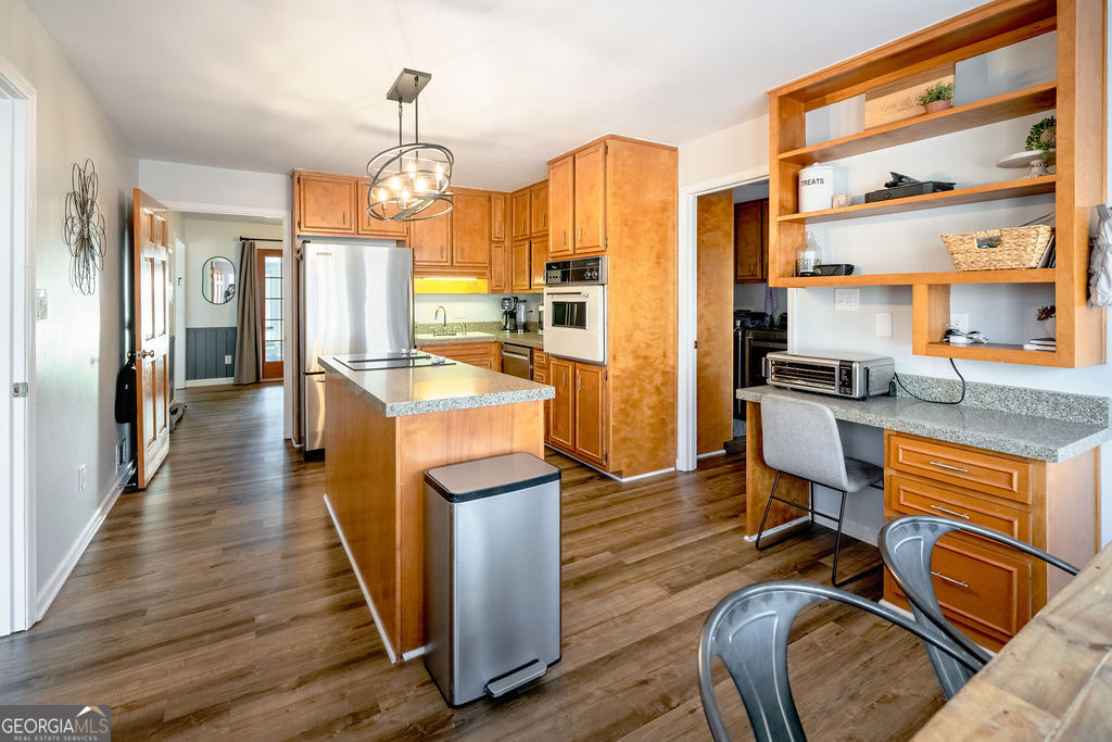 115 Devilla Trace Fayetteville, GA 30214 - Photo 9 of 30 a kitchen with stainless steel appliances granite countertop a stove top oven a refrigerator a dining table and chairs with wooden floor