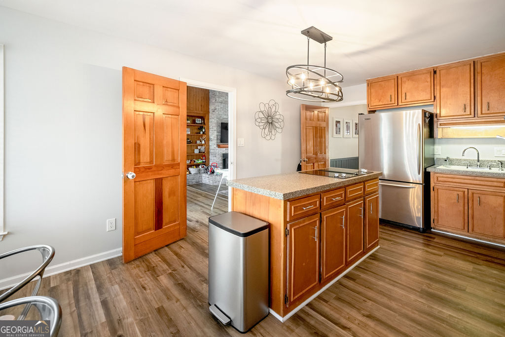 115 Devilla Trace Fayetteville, GA 30214 - Photo 10 of 30 a kitchen with stainless steel appliances granite countertop a refrigerator a sink dishwasher a stove and a dining table with wooden floor