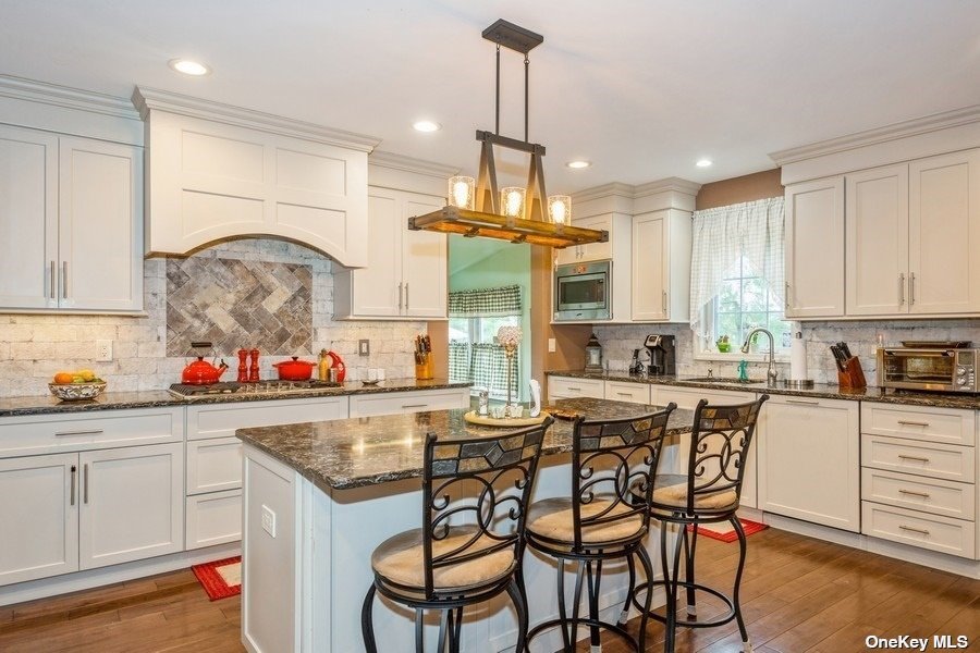 a kitchen with stainless steel appliances granite countertop a table and chairs in it