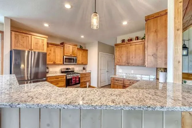 a large kitchen with stainless steel appliances kitchen island granite countertop a sink and cabinets