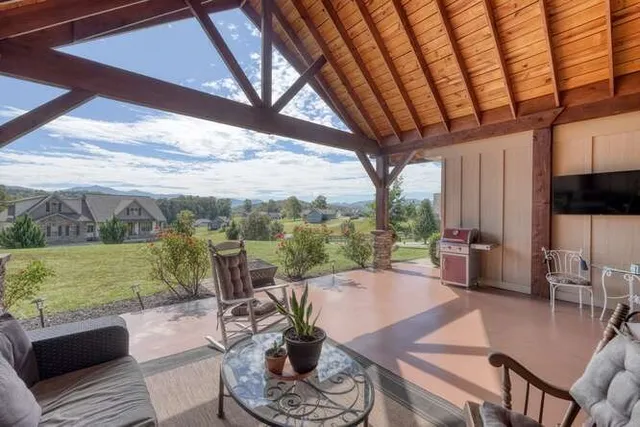 a view of a patio with couches chairs dining table and chairs with wooden floor