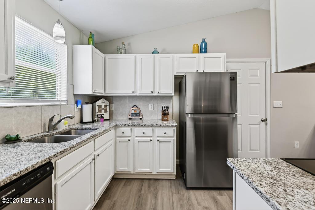 17080 Mcintosh Road Hilliard, FL 32046 - Photo 13 of 52 a kitchen with a sink refrigerator and cabinets