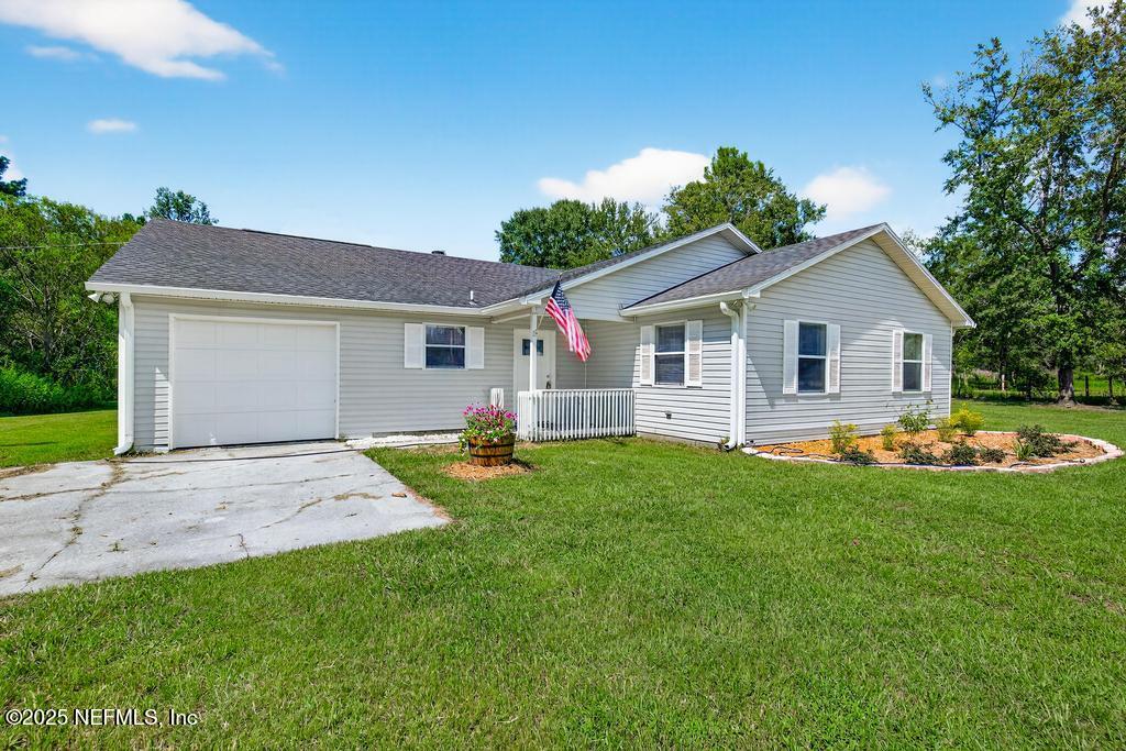 17080 Mcintosh Road Hilliard, FL 32046 - Photo 2 of 52 a view of a yard in front of a house with green space