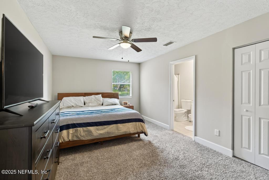 17080 Mcintosh Road Hilliard, FL 32046 - Photo 32 of 52 a bedroom with a bed and a flat tv screen on the dresser