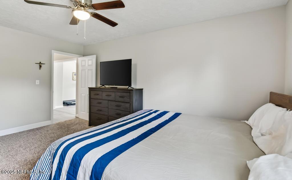 17080 Mcintosh Road Hilliard, FL 32046 - Photo 33 of 52 a bedroom with a bed and a flat screen tv