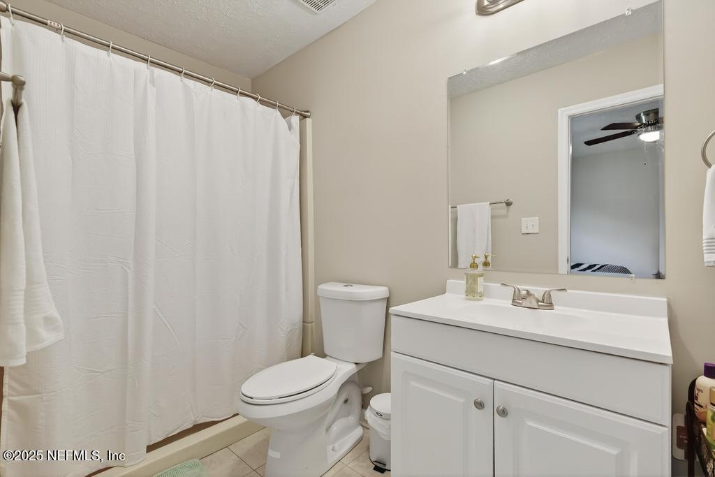 17080 Mcintosh Road Hilliard, FL 32046 - Photo 34 of 52 a bathroom with a sink a toilet and shower curtain