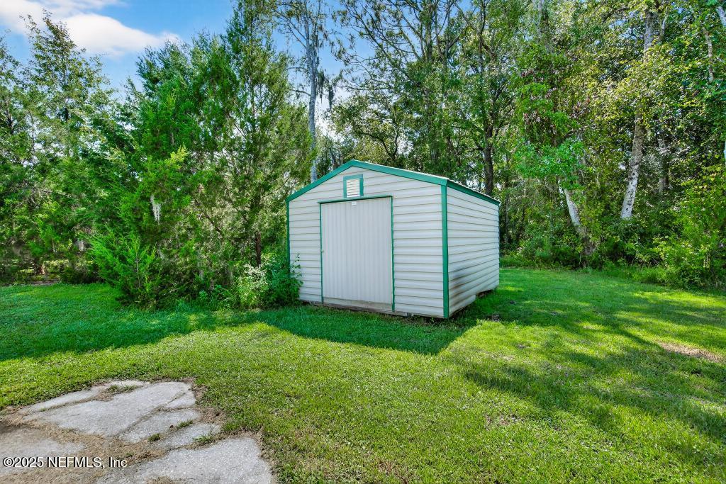 17080 Mcintosh Road Hilliard, FL 32046 - Photo 36 of 52 a backyard of a house with large trees and plants