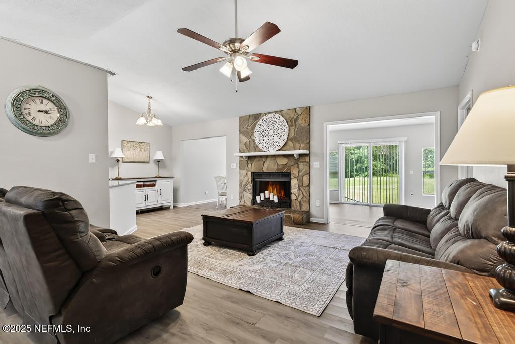 17080 Mcintosh Road Hilliard, FL 32046 - Photo 8 of 52 a living room with furniture a large window and a fireplace