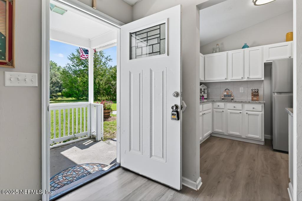 17080 Mcintosh Road Hilliard, FL 32046 - Photo 9 of 52 a open kitchen with white cabinets and wooden floor