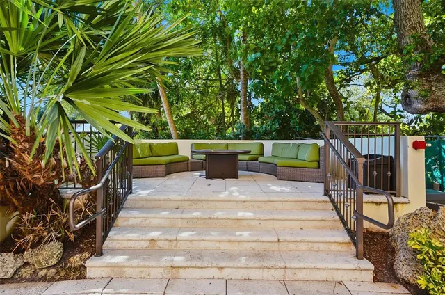 a view of a chairs and tables in the patio next to a yard