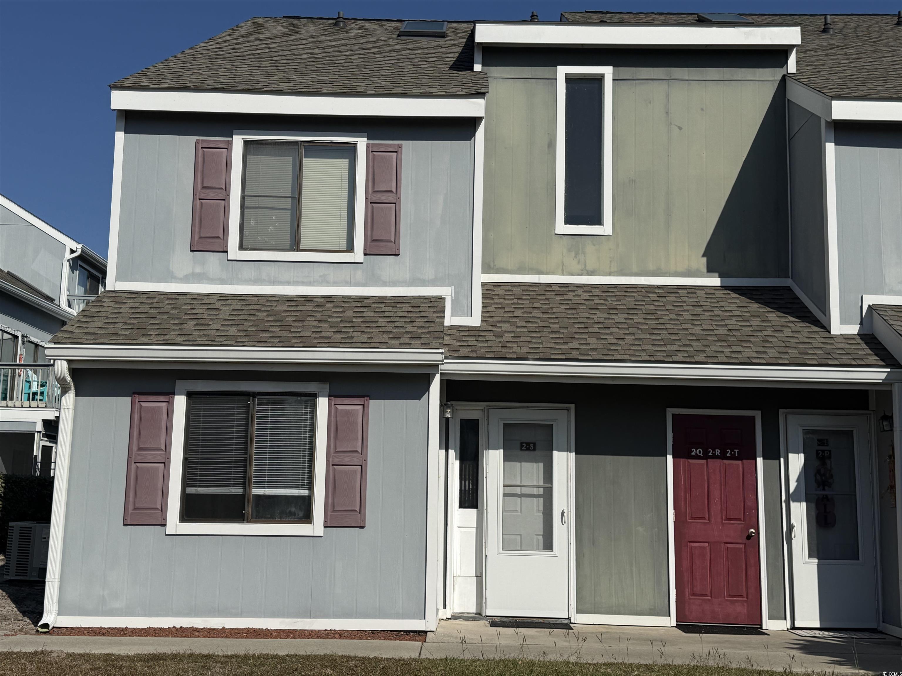 View of front facade featuring a shingled roof and covered porch