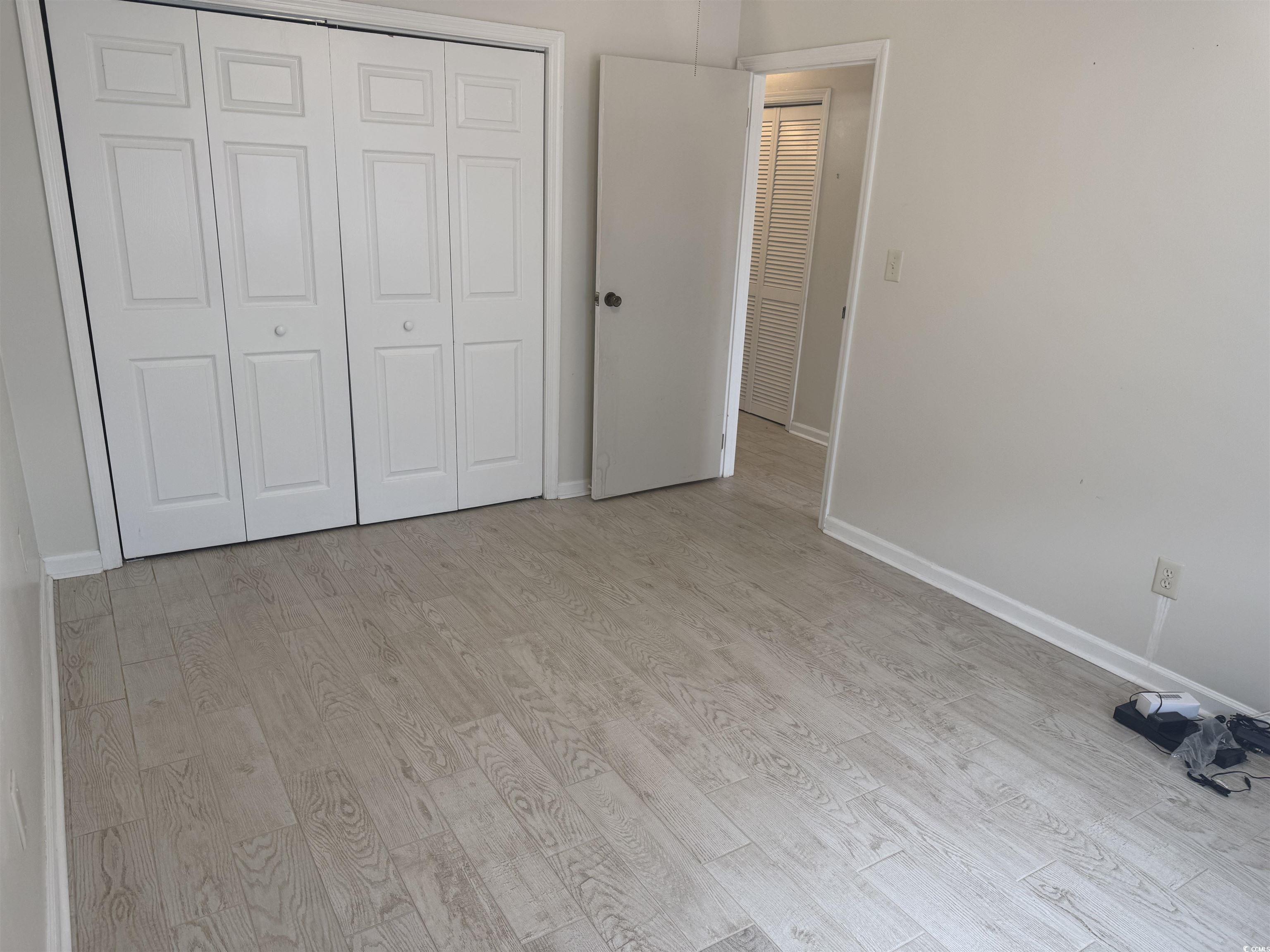 1850 Colony Drive, Unit 2S Myrtle Beach, SC 29575 - Photo 3 of 38 Unfurnished bedroom featuring light wood finished floors and a closet