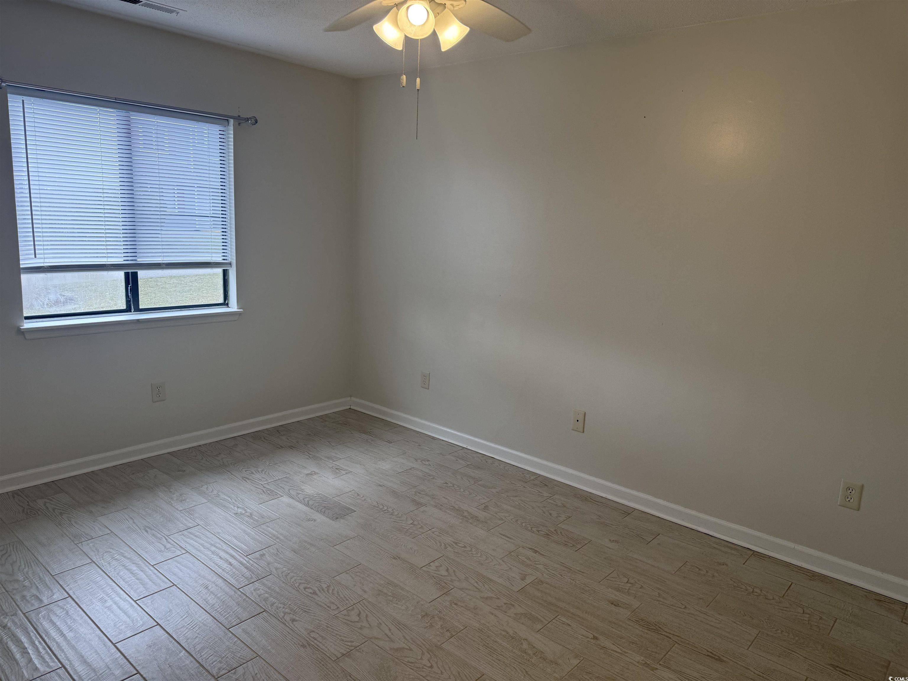 1850 Colony Drive, Unit 2S Myrtle Beach, SC 29575 - Photo 4 of 38 Empty room with light wood finished floors and a ceiling fan