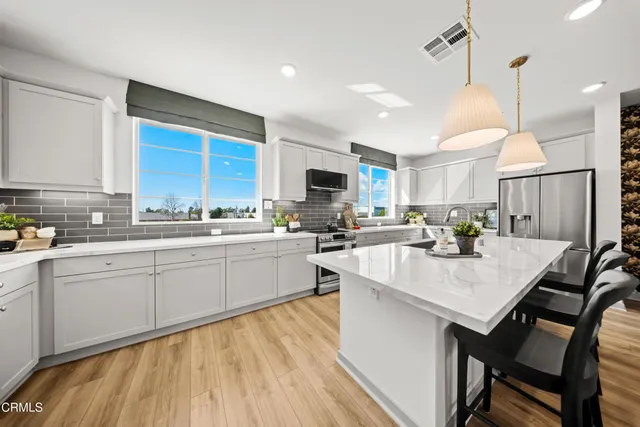 a kitchen with a table chairs sink and cabinets