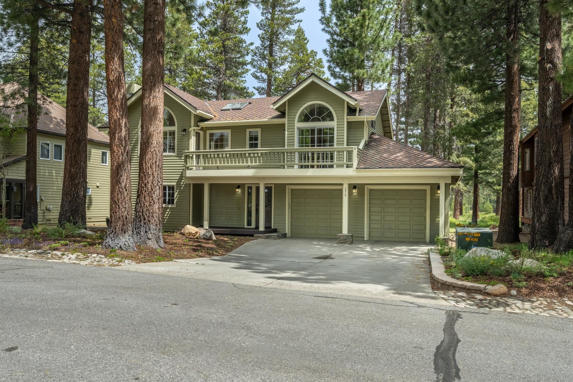 272 Ridge Way Mammoth Lakes, CA 93546 - Photo 5 of 55 Two-story residence featuring a two-car garage with individual doors, a second-story balcony with railings, and an arched window