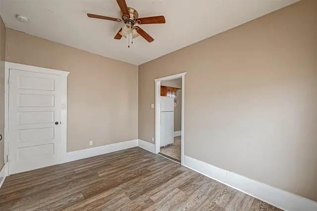 a view of empty room with wooden floor