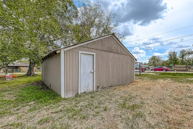 a view of backyard of house with wooden fence