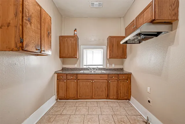 a bathroom with a granite countertop sink a mirror and a shower
