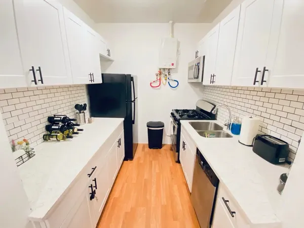 a kitchen with stainless steel appliances a sink dishwasher and a refrigerator